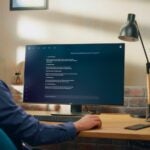 Creative Prompt Engineer Sits at a Desk Using a Computer, Using AI Chatbot Virtual Assistant.