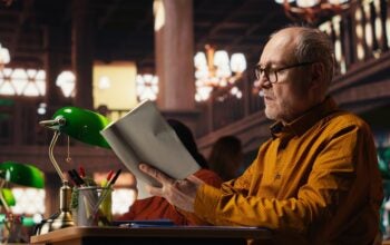 man immersed in reading and writing at a university campus library