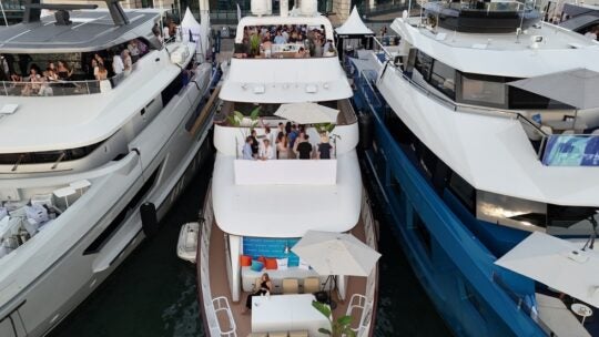 Aerial view of luxury yachts moored in the Old Port during the Cannes Lions International Festival of Creativity. Guests gather on the decks of private vessels, including those chartered for Equativ, to network during the world-renowned advertising and marketing event.