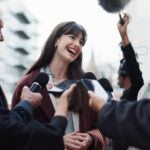 Woman, publicist and press with questions, city and discussion with reporters for interview. publicist outdoors with journalists for campaign updates, news and people with mic