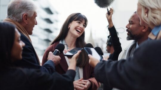 Woman, publicist and press with questions, city and discussion with reporters for interview. publicist outdoors with journalists for campaign updates, news and people with mic