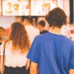 young man standing in a restaurant cash register queue