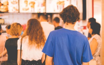 young man standing in a restaurant cash register queue