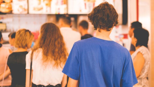 young man standing in a restaurant cash register queue