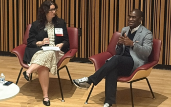 Nicole Schuman and AJ Jones II talking onstage at Mid-Atlantic MarComm Summit in October 2026