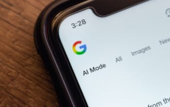 Macro shot of a smartphone screen showing the Google website with "AI Mode" selected, highlighting AI-enhanced search features.