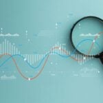 Magnifying glass over digital data graph and charts. Business analytics, financial market research, and statistics concept. Stock market, investment, and data audit.